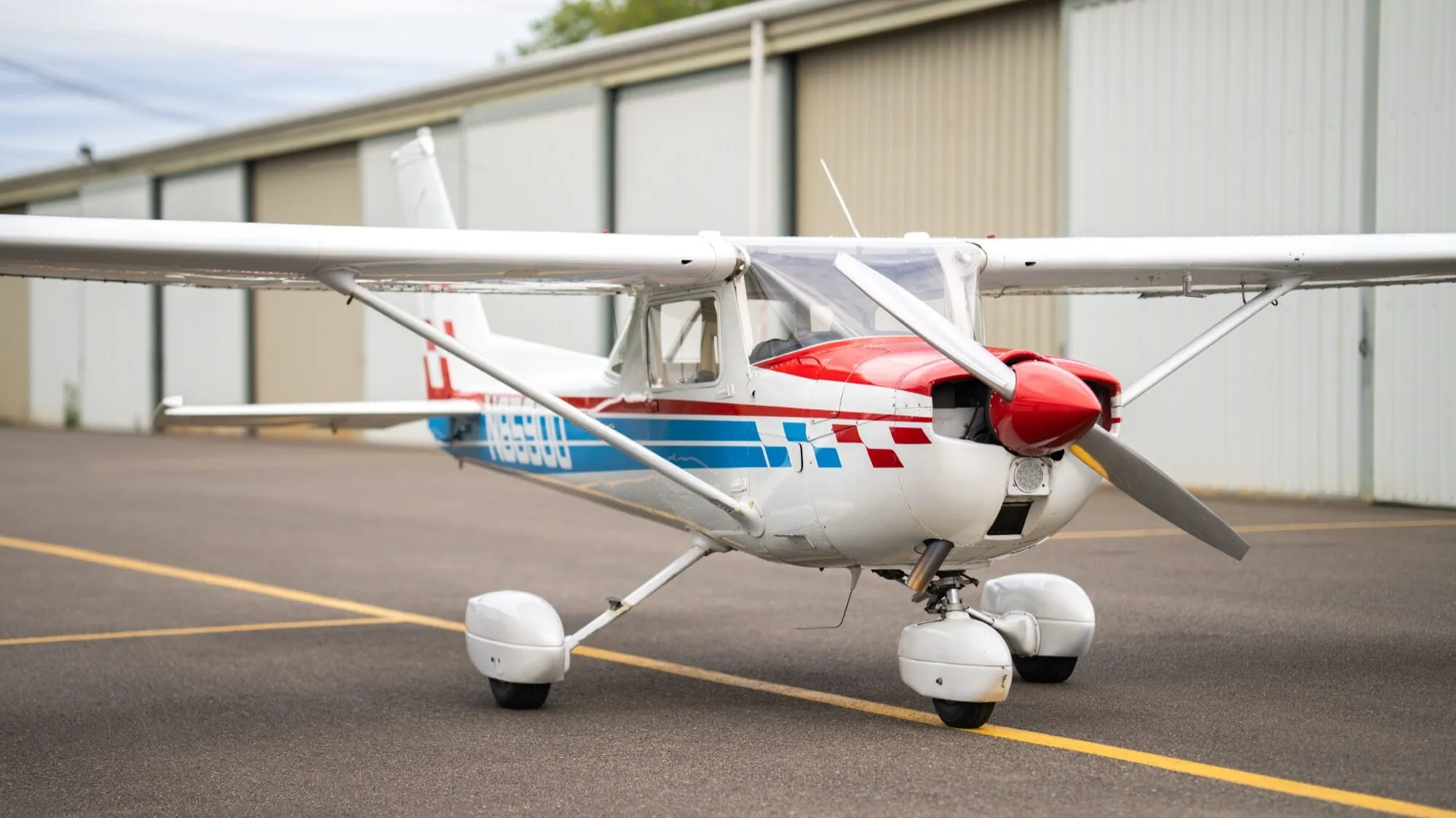 Red, white and blue Cessna 150M on the ramp