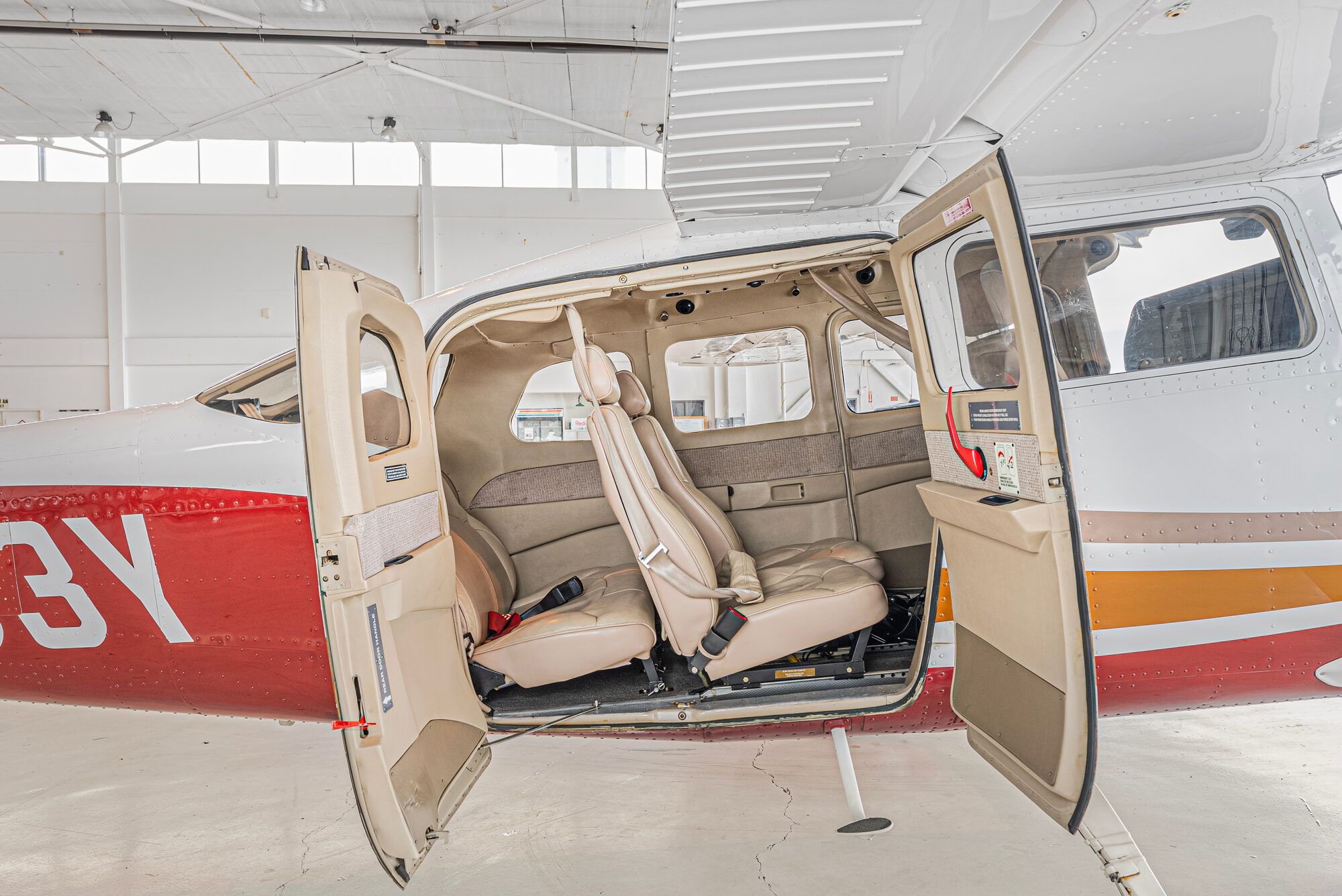 Cessna Turbo Stationair with both cabin doors open, showing the tan leather rear seats