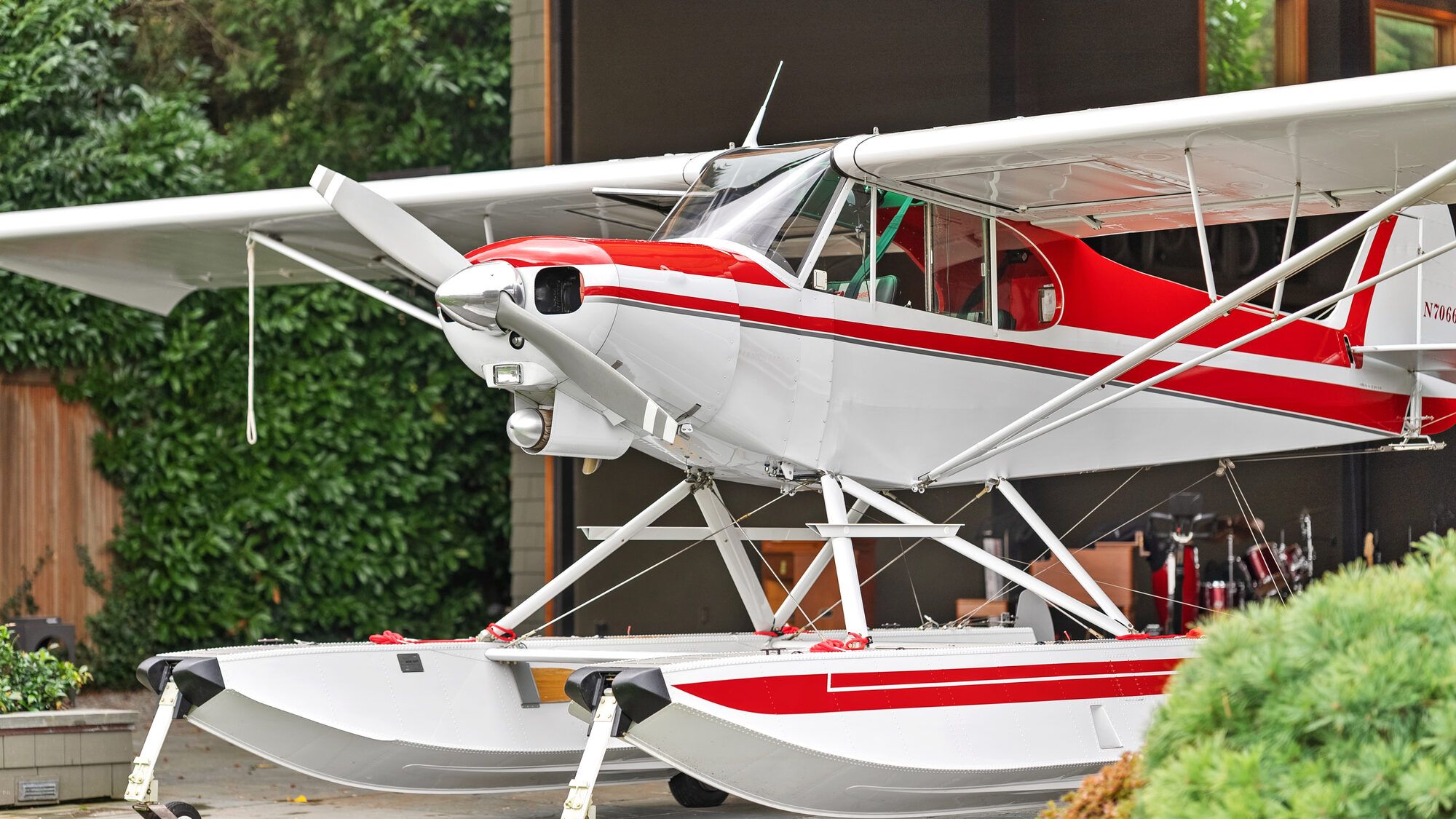 Super Cub on floats from the front left, close up, with a house behind