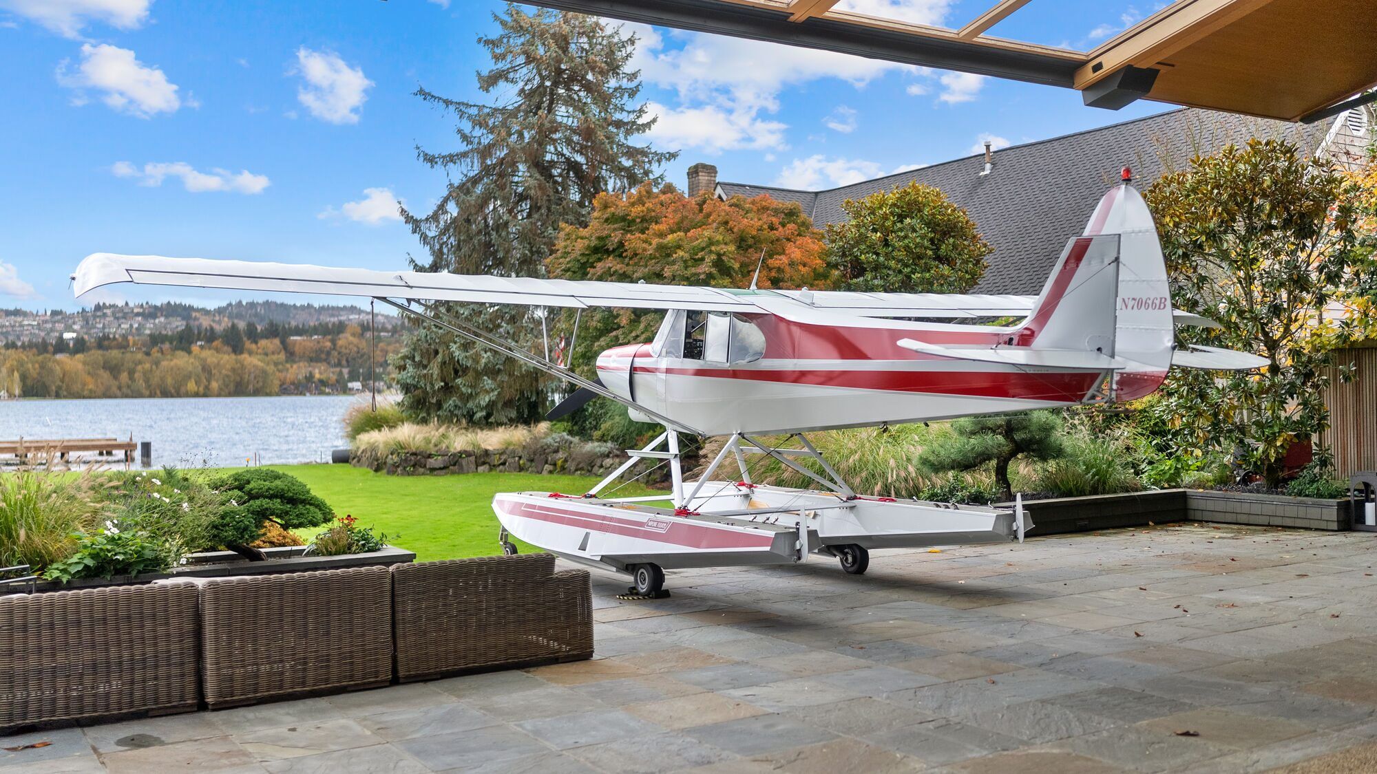 Float-equipped aircraft parked on a terrace beside a lake