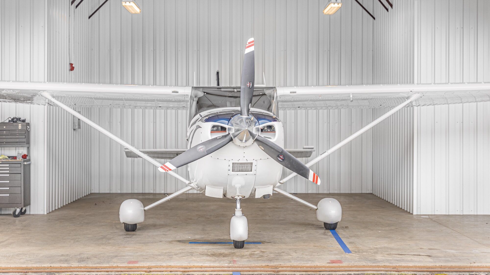 Cessna Turbo Skylane nose, cowl and three-blade propeller inside a hangar